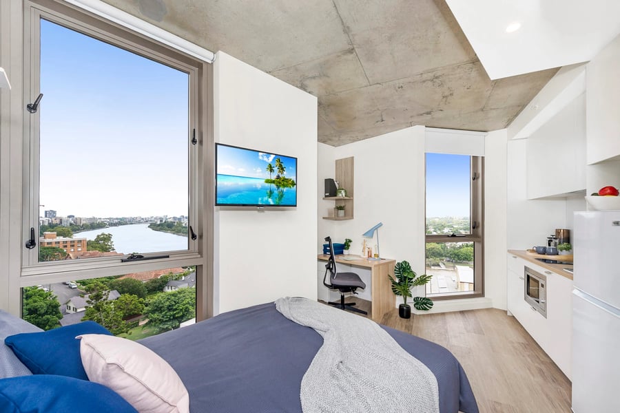 Bed desk TV kitchen and river view studio at Scape St Lucia in Brisbane Student Accommodation