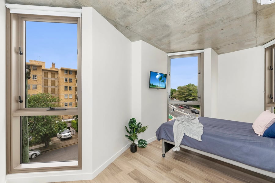 Bed television plant with city view bedroom at Scape St Lucia in Brisbane Student Accommodation