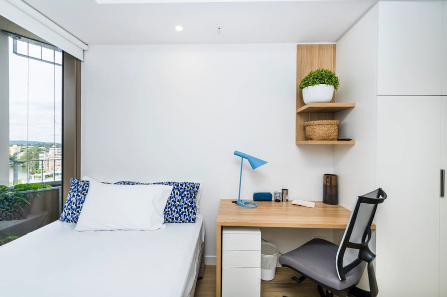 Bed desk chair shelves plants and window bedroom at Scape St Lucia in Brisbane Student Accommodation
