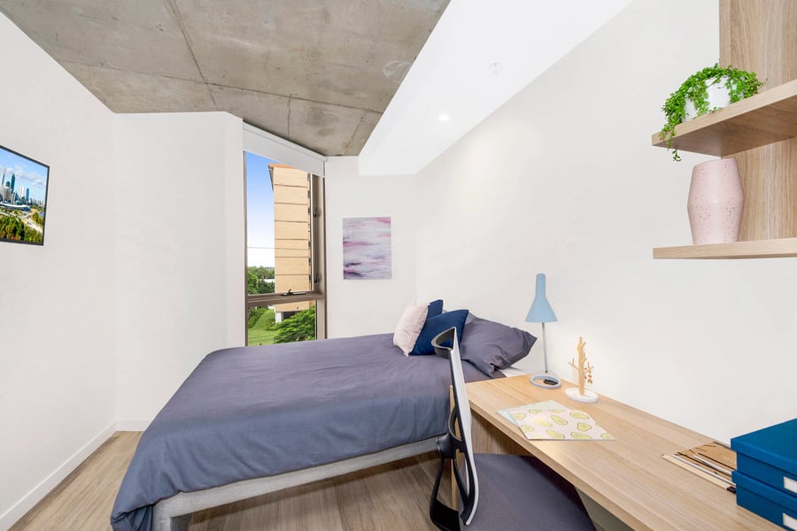 Bed desk lamp and chair bedroom interior at Scape St Lucia in Brisbane Student Accommodation