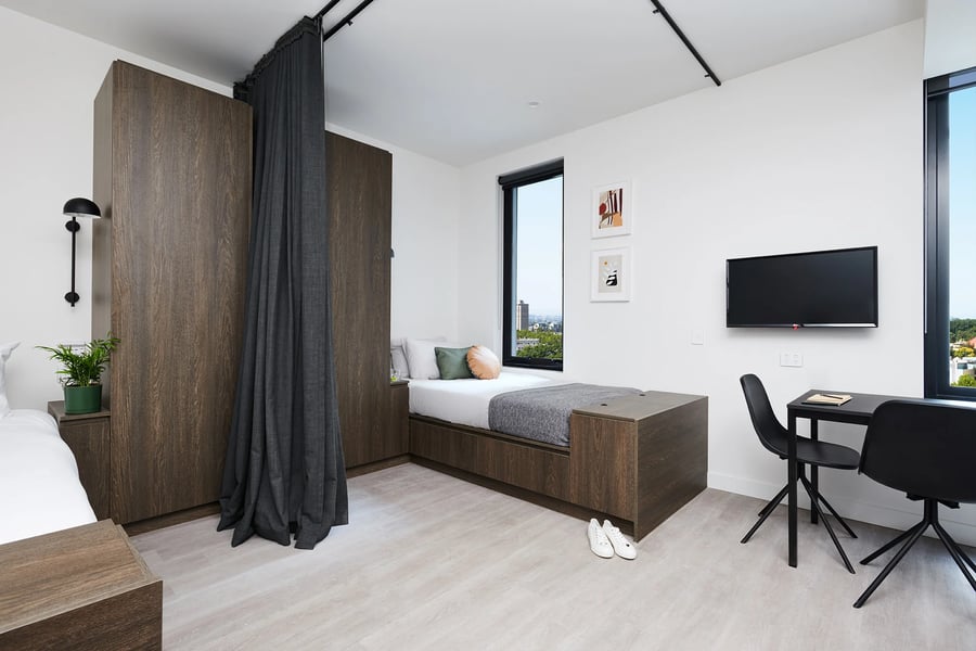Bed desk TV with dark cabinets and curtain Bedroom at Scape Cornell Place in Melbourne Student Accommodation
