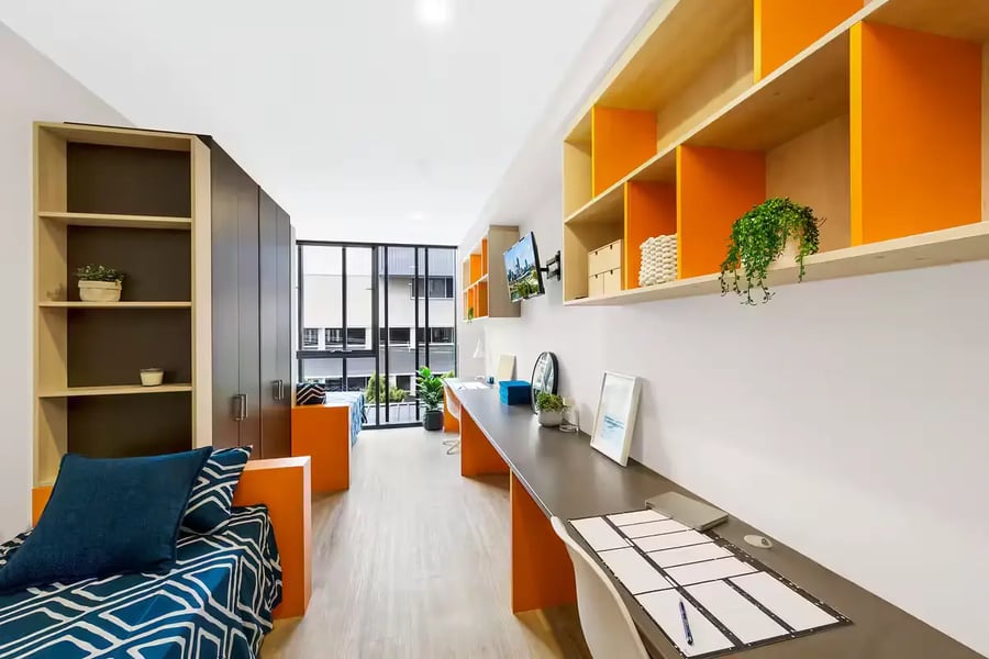 Beds desks shelves and TV student accommodation bedroom at Scape Merivale in Brisbane Student Accommodation