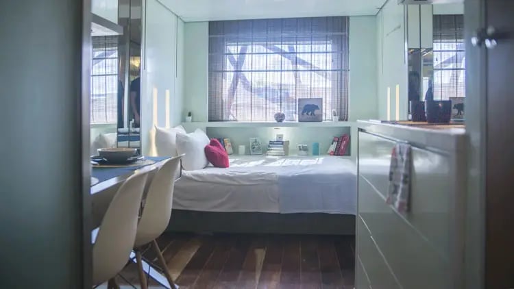Bed pillows books and chairs bedroom at The Stay Club - Camden in London Student Accommodation