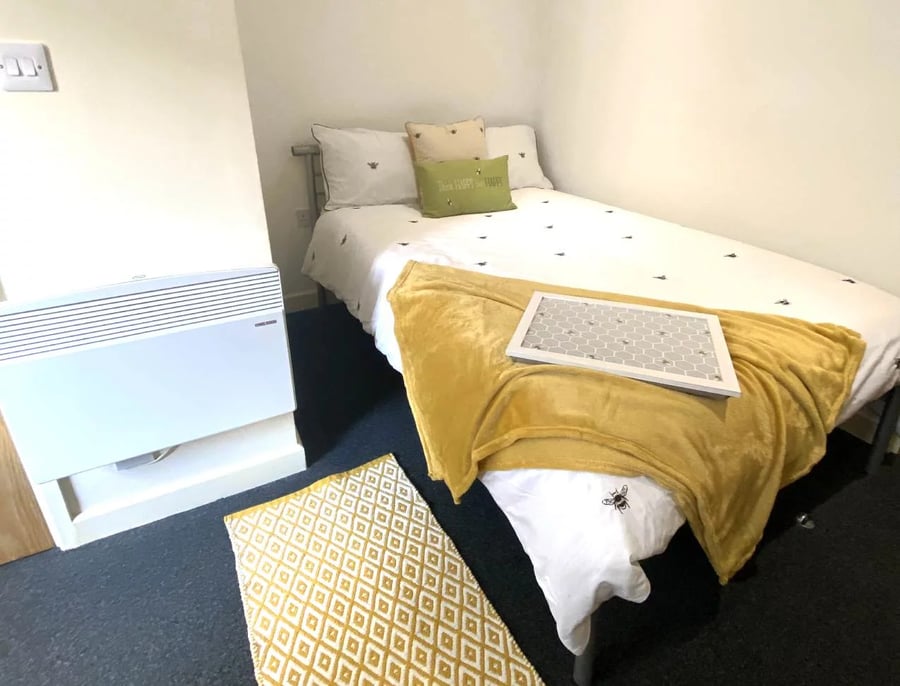 Bed with bee pattern yellow blanket framed picture bedroom at Radmoor House in Loughborough Student Accommodation