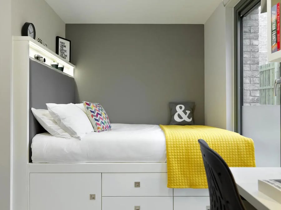 Bed with white linen yellow throw ampersand pillow bedroom at Student Castle Edinburgh in Edinburgh Student Accommodation