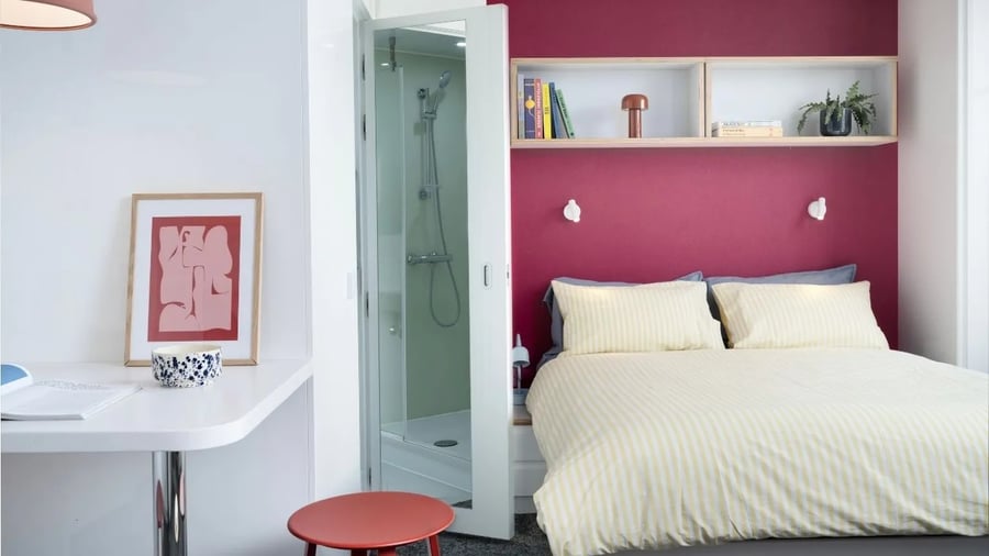 Bed shower framed art red stool bedroom at Scape Bloomsbury in London Student Accommodation