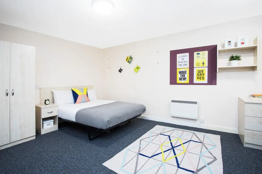 Bed wardrobe rug and bedside table bedroom at The Grange Leicester in Leicester Student Accommodation