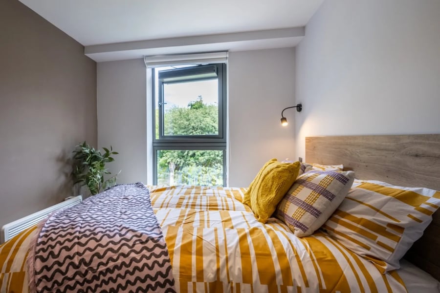 Bed with yellow patterned bedding bedside lamp bedroom at Murieston Crescent - Edinburgh in Edinburgh Student Accommodation
