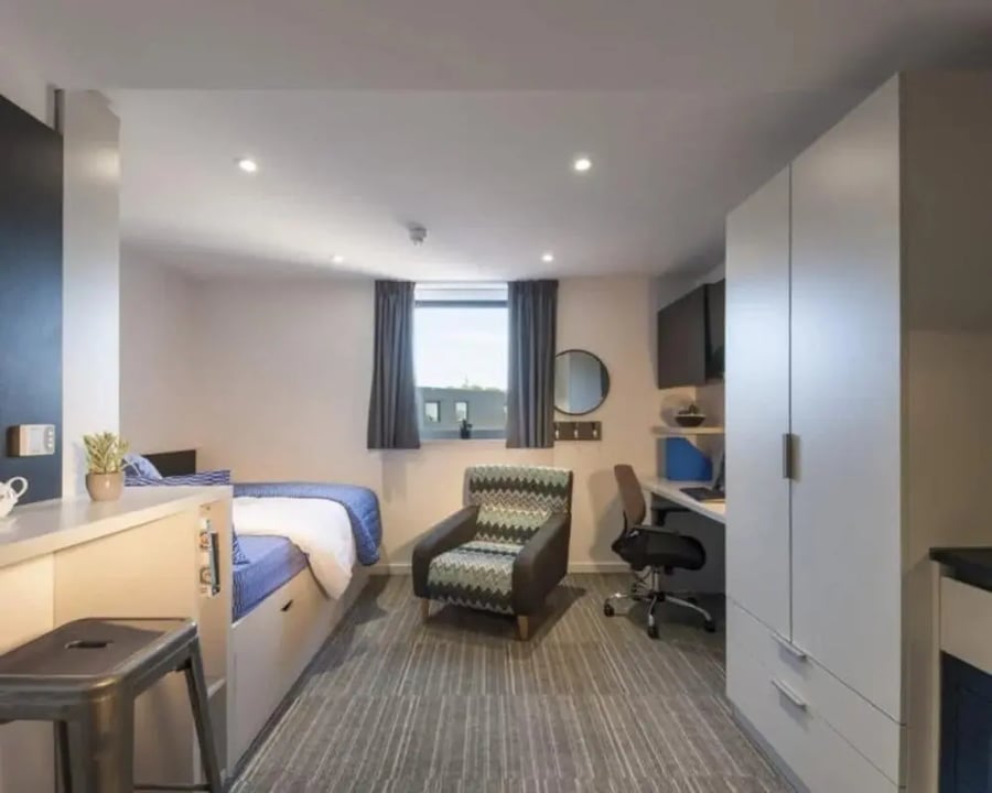 Bed desk chair wardrobe patterned armchair bedroom at New Park in Edinburgh Student Accommodation
