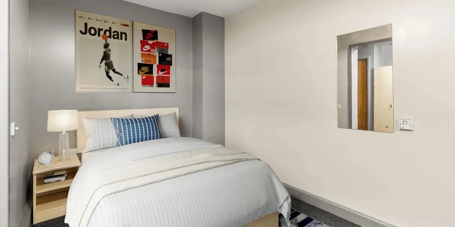 Bed with pillows lamp and posters Bedroom at The Heights in Birmingham Student Accommodation