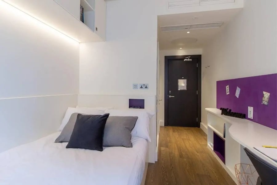 Bed with dark grey pillow on white bedding bedroom at Spring Mews in London Student Accommodation