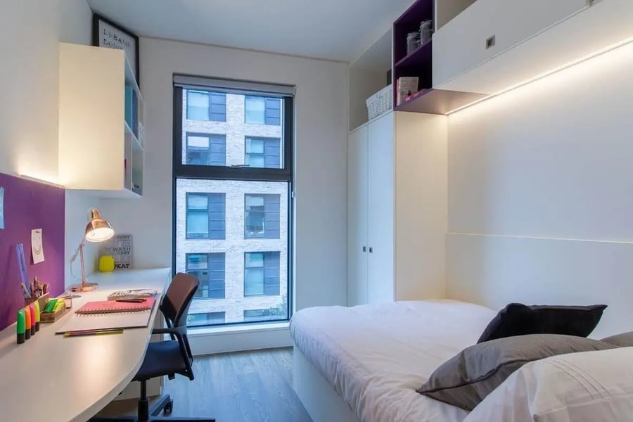 Desk chair lamp bed pillows wardrobe bedroom at Spring Mews in London Student Accommodation