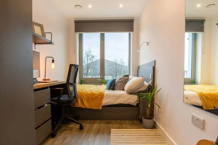 Bed desk chair and window student bedroom at Great Court in London Student Accommodation