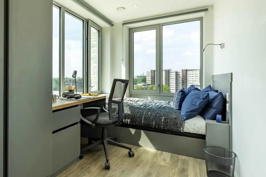 Desk chair bed with pillows bedroom at Great Court in London Student Accommodation