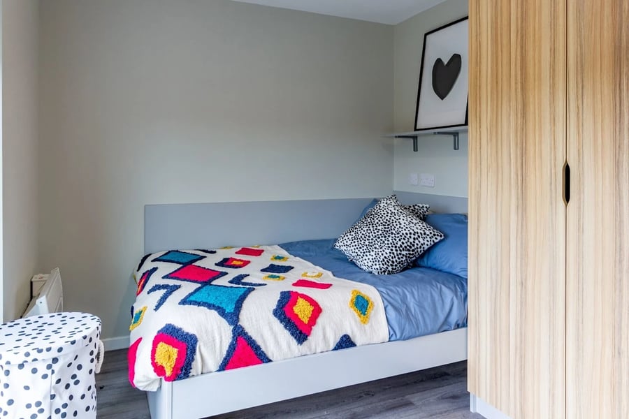 Bed with colorful throw and leopard print pillow bedroom at Gulson Gardens in Coventry Student Accommodation