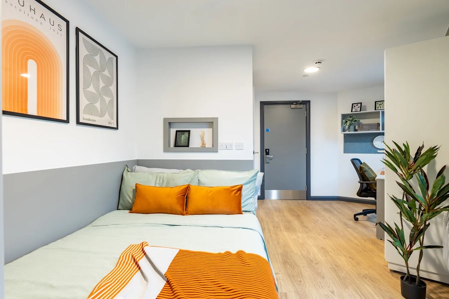 Bed with orange pillows study area bedroom at Winfield Court in Nottingham Student Accommodation