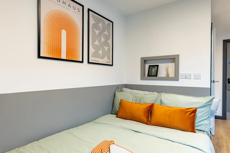 Bed with orange pillows modern art bedroom at Winfield Court in Nottingham Student Accommodation