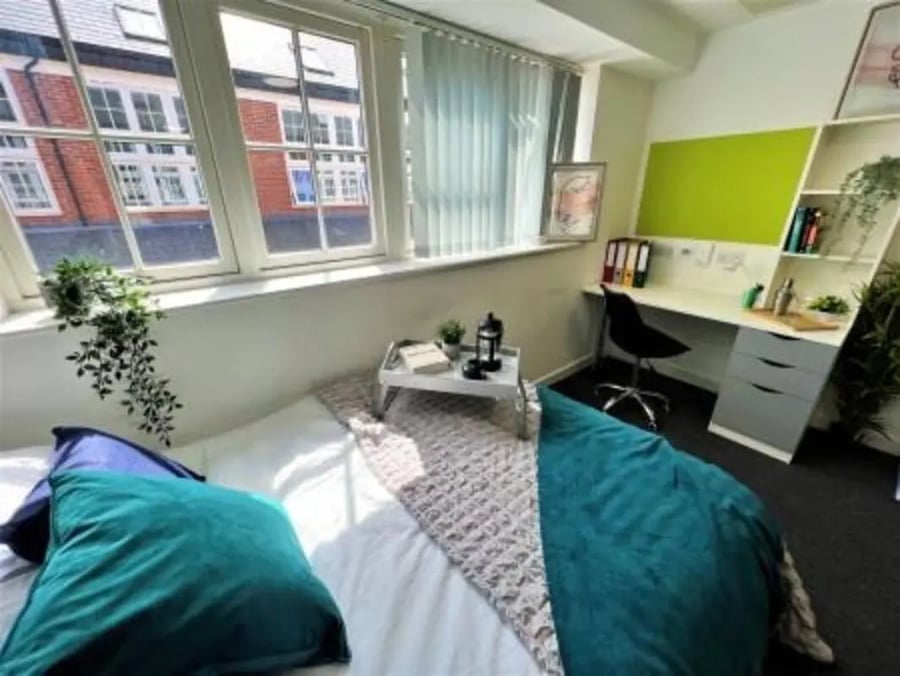 Bed pillows desk with chair and shelves Bedroom at Tudor Studios in Leicester Student Accommodation