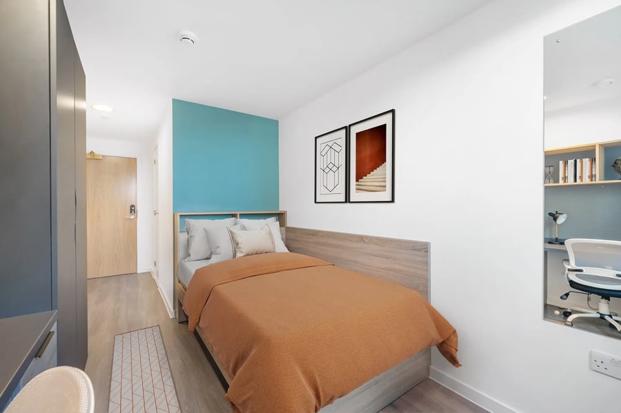 Bed with orange blanket study area with desk bedroom at Canvas Walthamstow in London Student Accommodation