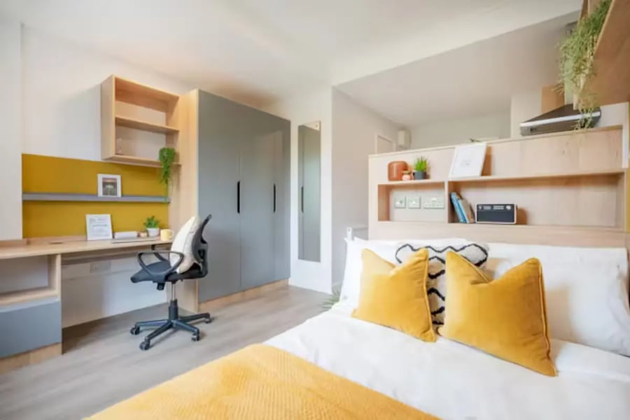 Desk wardrobe bed with yellow pillows bedroom at Hillfort House in Brighton Student Accommodation