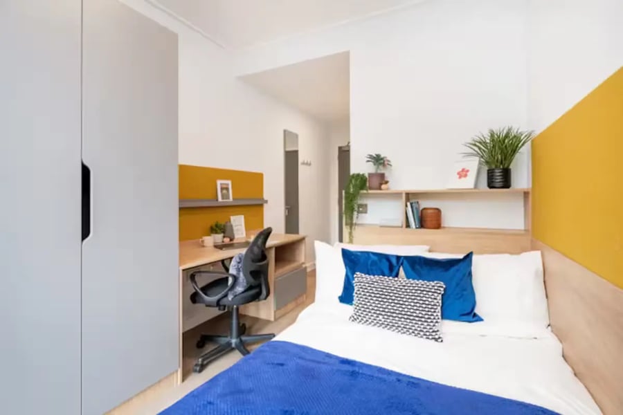 Wardrobe desk chair bed with pillows and blanket bedroom at Hillfort House in Brighton Student Accommodation