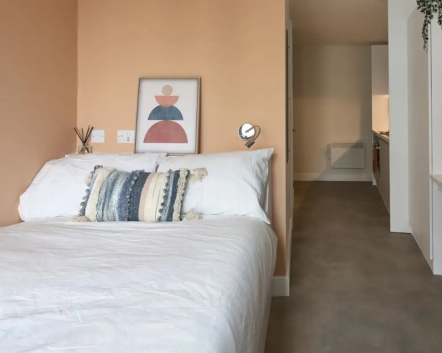 Bed with decorative pillow and abstract art Bedroom at Host View Studios in London Student Accommodation