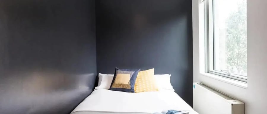 Bed with pillows near window bedroom at Chapter Kings Cross in London Student Accommodation