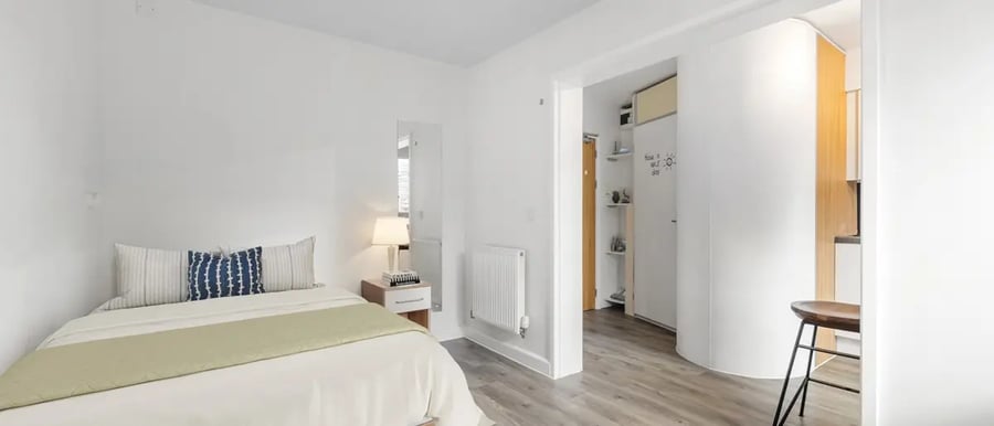 Bed bedside table pillows mirror and radiator bedroom at Chapter Highbury in London Student Accommodation