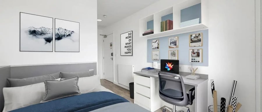 Bed with artwork desk with laptop study area at Chapter Highbury II in London Student Accommodation