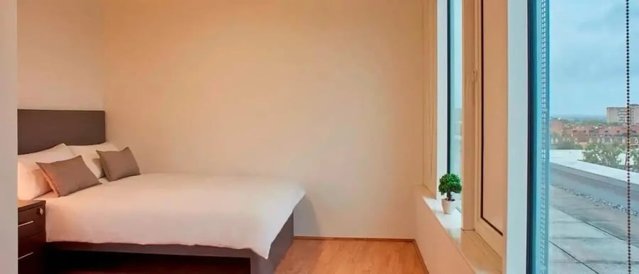 Bed with pillows and nightstand bedroom at Chapter Portobello in London Student Accommodation