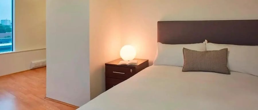 Bed bedside lamp and nightstand bedroom at Chapter Portobello in London Student Accommodation