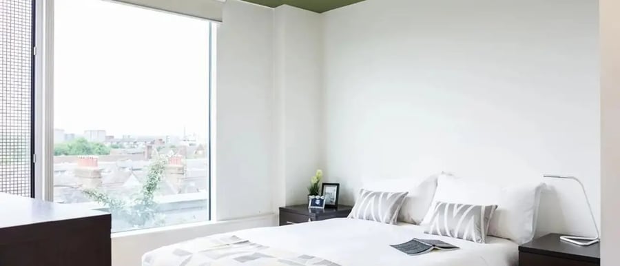 Bed bedside table lamp picture frame bedroom at Chapter Portobello in London Student Accommodation
