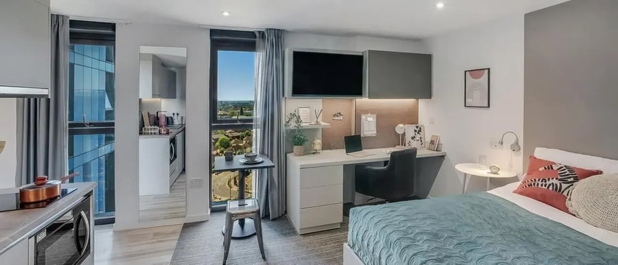 Bed desk and kitchen area studio at Chapter Ealing in London Student Accommodation
