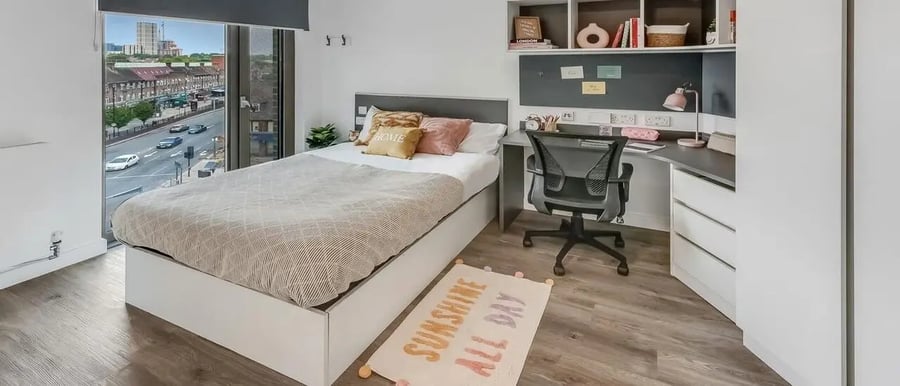 Bed desk chair rug and window view bedroom at Chapter White City in London Student Accommodation