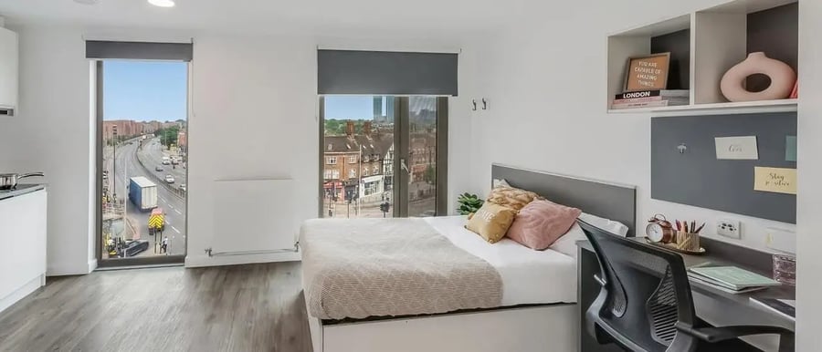 Bed desk and shelves with city view bedroom at Chapter White City in London Student Accommodation