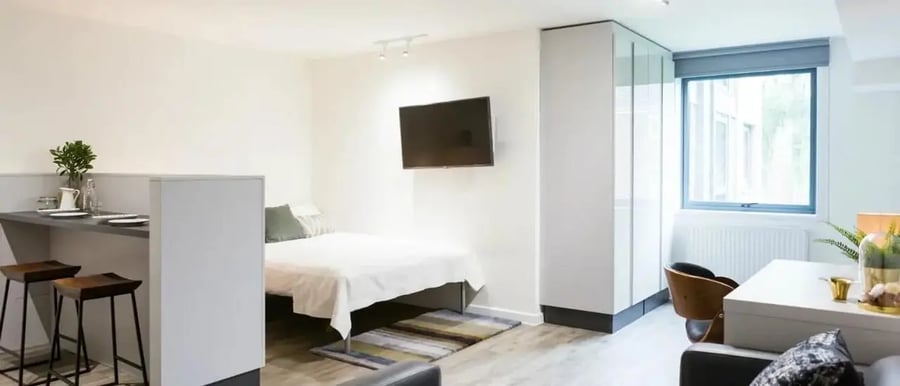 Bed TV bar stools and window studio apartment at Chapter Islington in London Student Accommodation