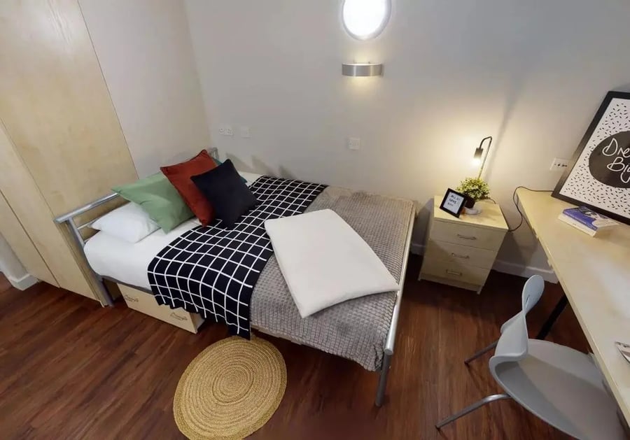 Bed desk pillows rug and nightstand bedroom at iQ Arkwright House in Bradford Student Accommodation