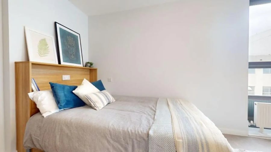 Bed with pillows and artwork bedroom at iQ Sterling Court in London Student Accommodation