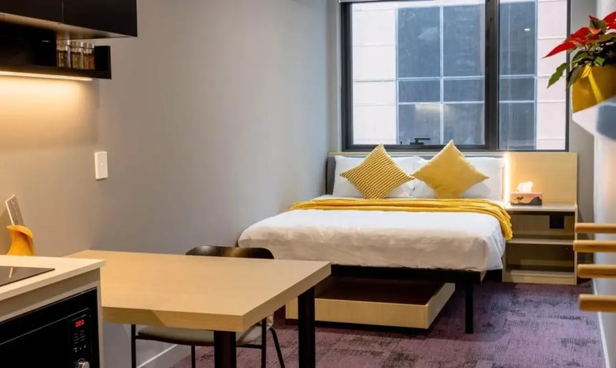 Bed, table, kitchen area, bedroom at The Switch Melbourne Victoria Market in Melbourne Student Accommodation