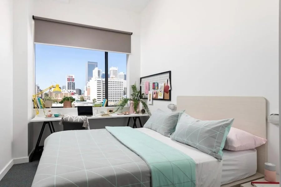 Bed study desk plants city view bedroom at Campus Perth in Perth Student Accommodation