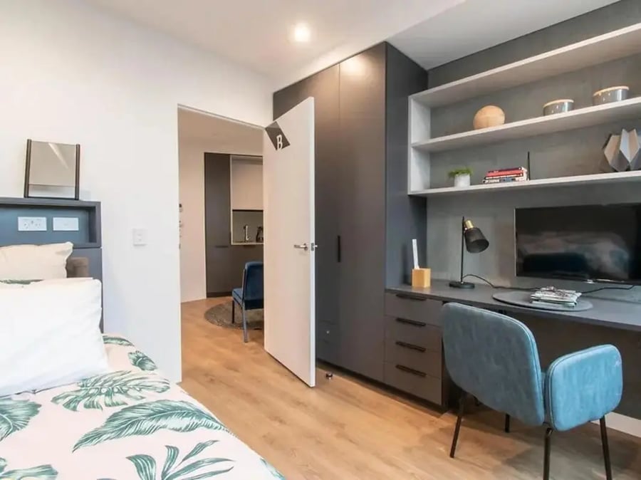Bed study area with desk chair and television Bedroom at Yugo University Square Melbourne in Melbourne Student Accommodation