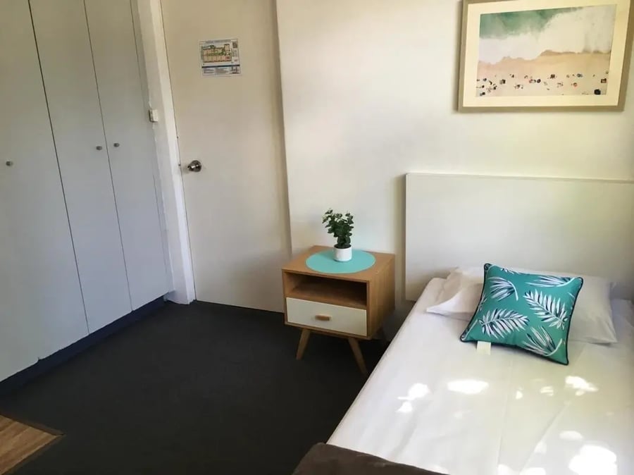 Bed nightstand plant artwork and closet bedroom at ume Hyde Park in Sydney Student Accommodation