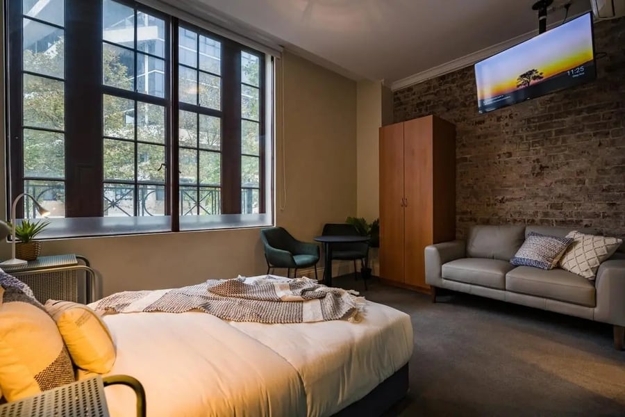 Bed couch closet and TV bedroom at ume Haymarket in Sydney Student Accommodation