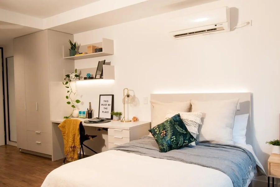 Bed desk plants and air conditioner bedroom at Yugo Berkeley Street in Melbourne Student Accommodation