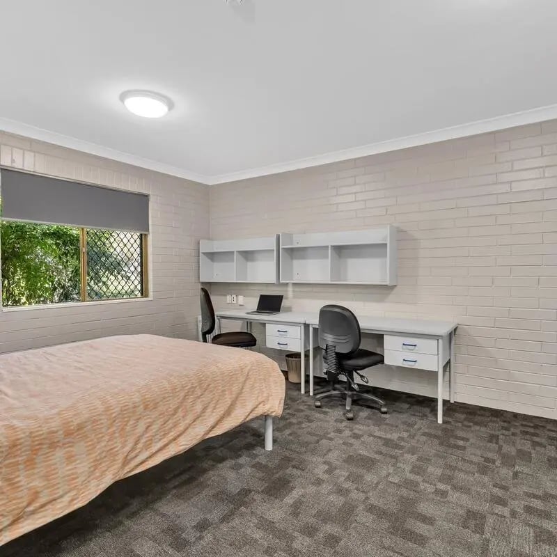 Bed desks chairs and laptop study area at Murdoch University Village in Perth Student Accommodation