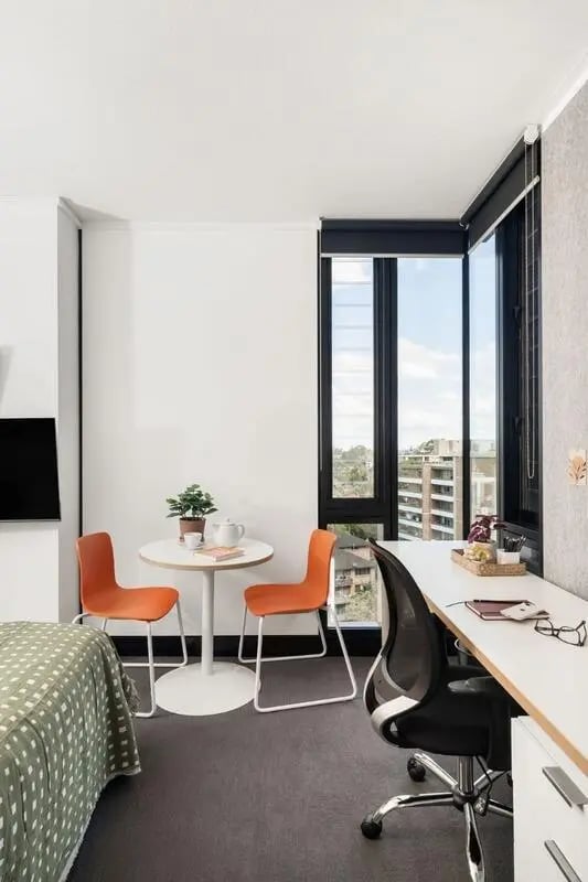 Desk chairs table and bed student room at Iglu Chatswood in Sydney Student Accommodation