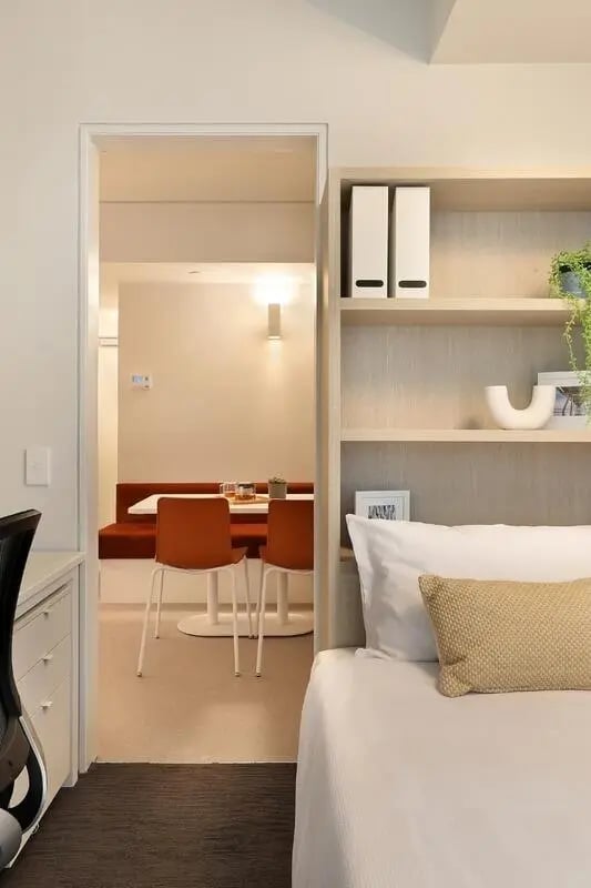 Desk shelving bed and dining area kitchen at Iglu Flagstaff Gardens in Melbourne Student Accommodation