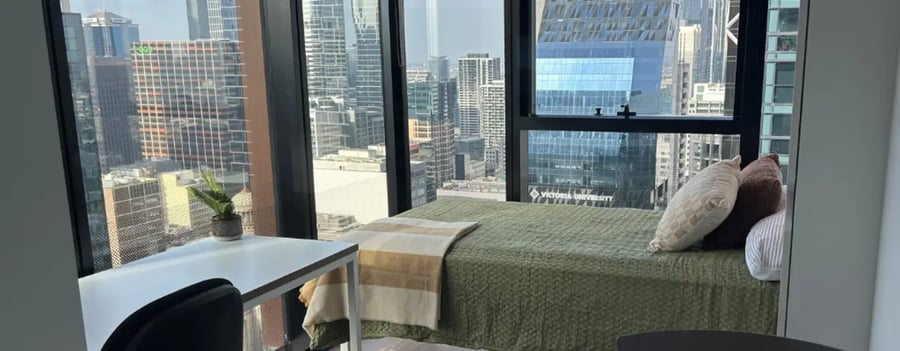Bed desk plant cityscape bedroom at UniLodge Melbourne Central in Melbourne Student Accommodation