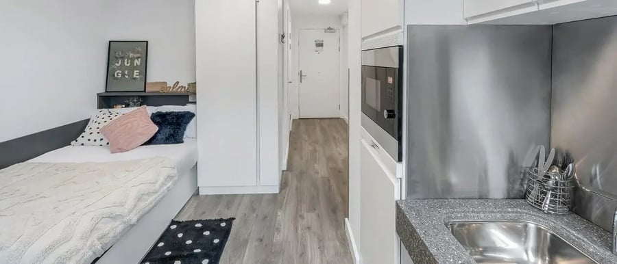 Bed with pillows microwave and sink kitchen at Chapter White City in London Student Accommodation