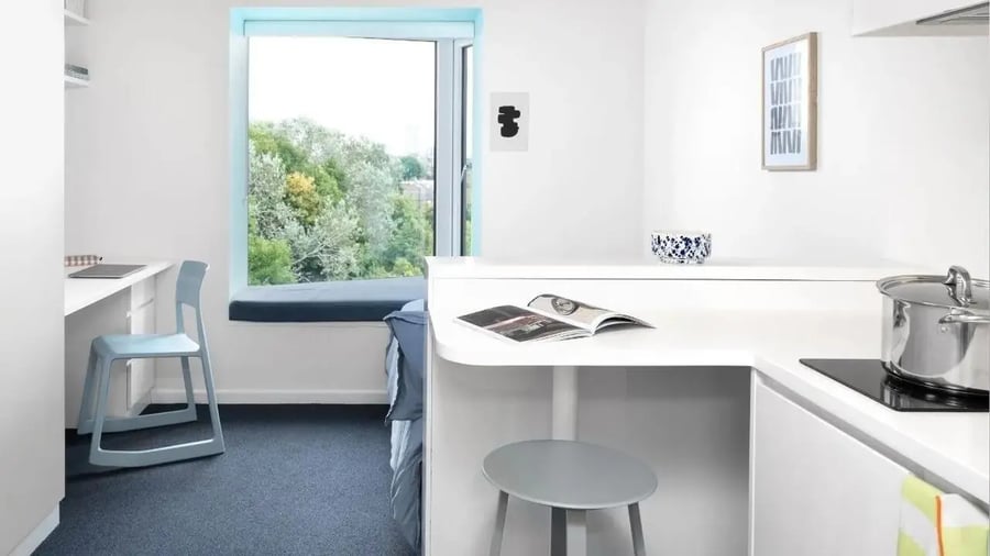 Desk chair window bed kitchen counter cooking pot study area at Scape Mile End in London Student Accommodation